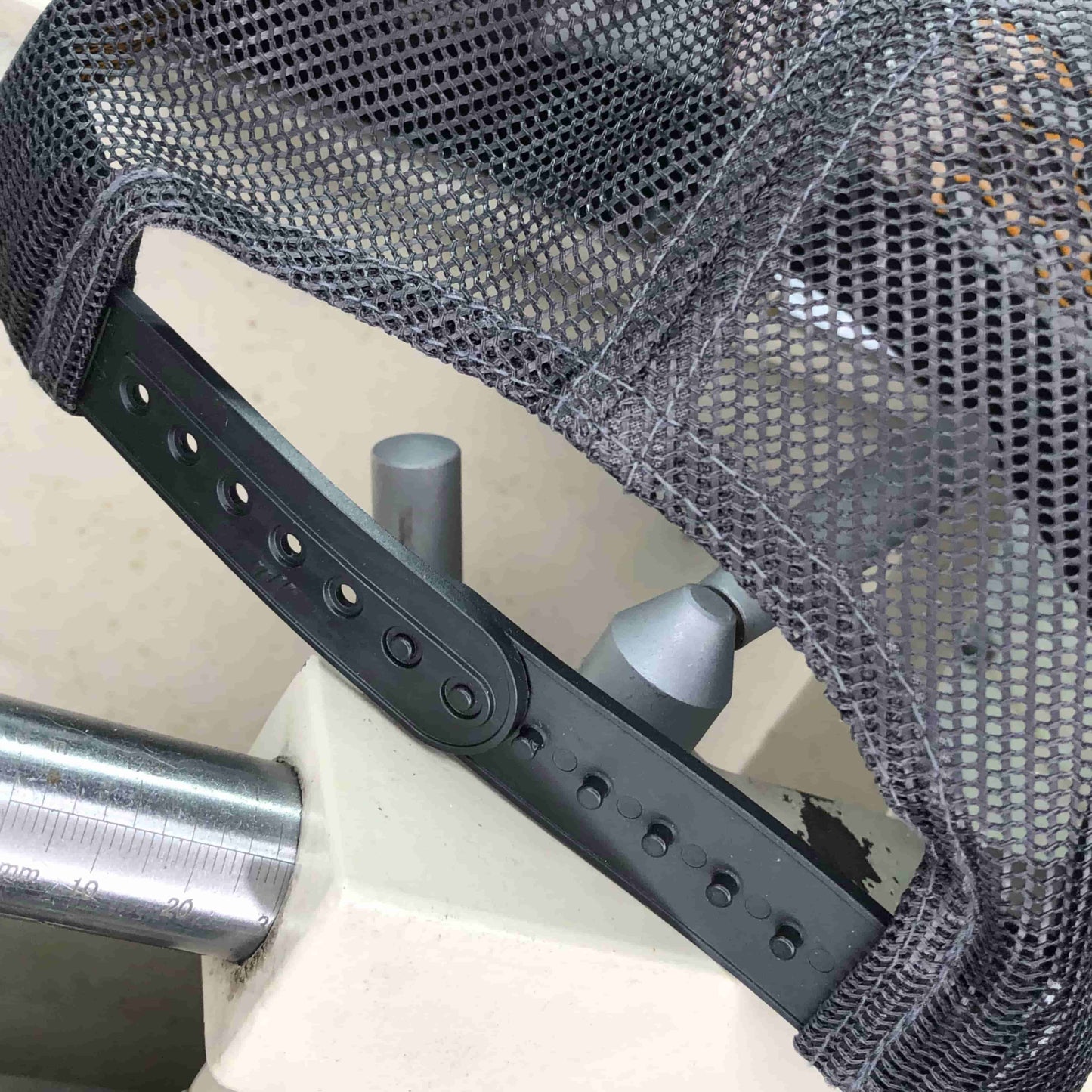 Back view of adjustable closure on the Miller Machine 5 panel trucker cap with Flaming M in red and yellow. Cap is a grey color.