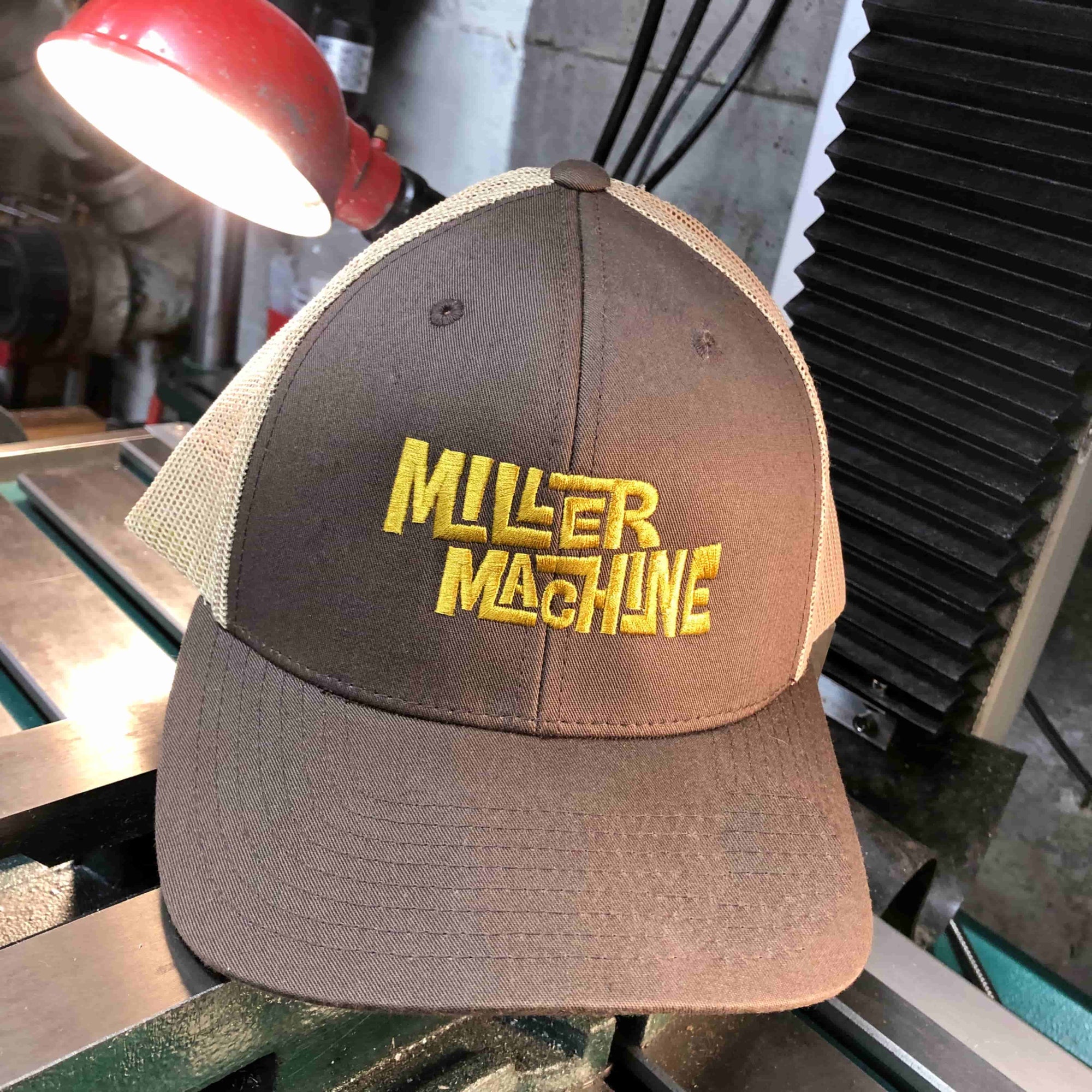 Photo of Miller Machine Trucker Cap in brown, with gold embroidery.