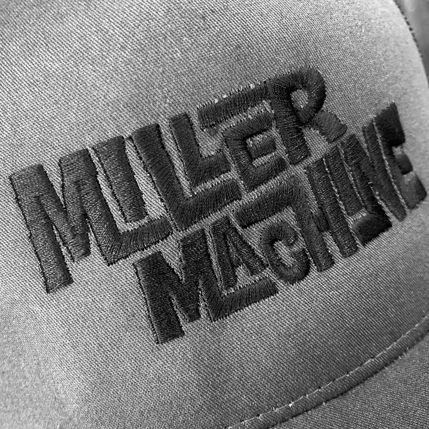 Closeup photo of "Miller Machine" cap with custom embroidered stitching.